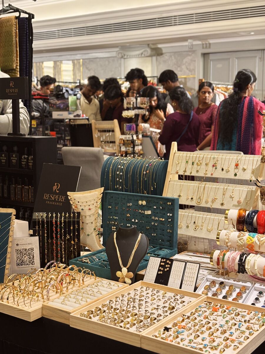 A jewellery stall lined with rings and bangles, busy with shoppers behind